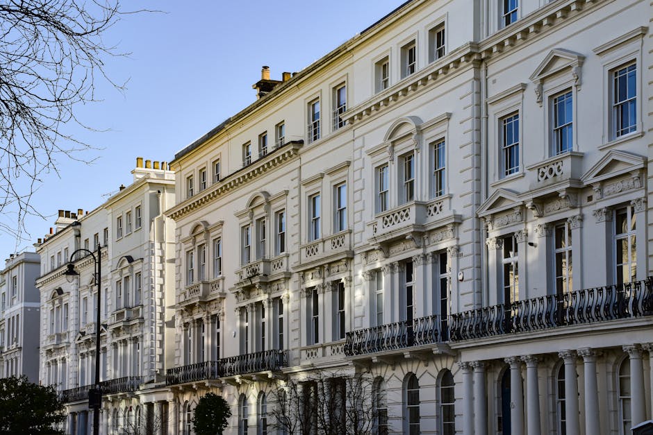 A multi-storey Victorian-style building with a white facade and decorative architectural details, including ornate window frames and small balconies with iron railings, is visible in this image taken